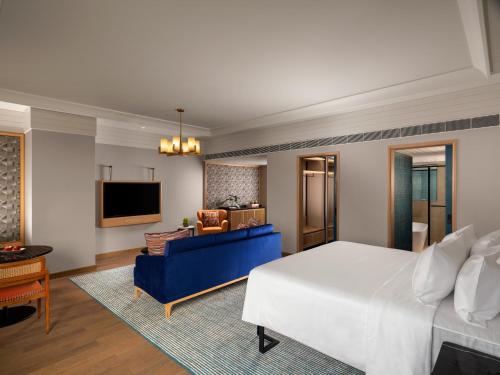 a hotel room with a large bed and a living room at Pullman Chennai Anna Salai - Premium Brand By Accor in Chennai