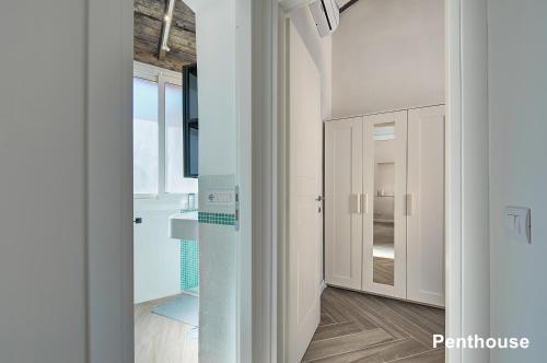 a bathroom with white cabinets and a glass door at Casa a Monti in Rome