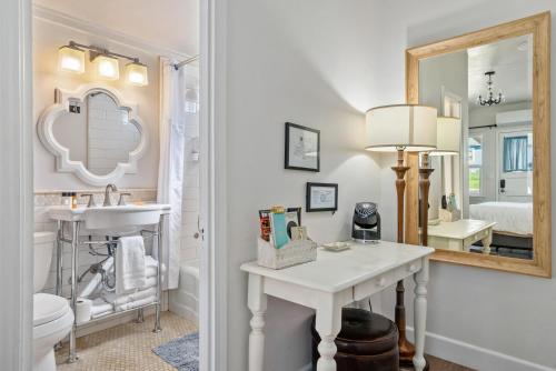 ein Badezimmer mit Waschbecken, Toilette und Spiegel in der Unterkunft Chestnut Cottage in Paso Robles