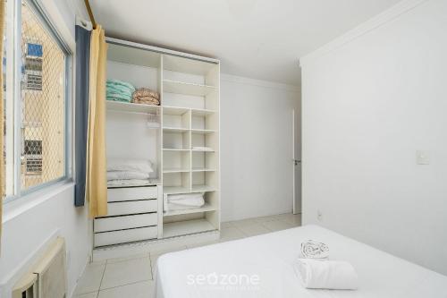 Una habitación blanca con un armario con estantes blancos. en Apartamentos com Piscina em Floripa - CAC, en Florianópolis