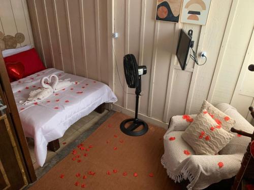 a small room with a bed and a chair at Santo Gole Ilha Do Mel in Ilha do Mel