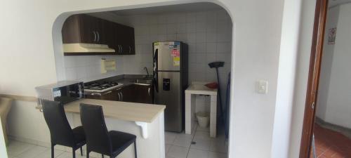 a kitchen with a refrigerator and a table and chairs at 2 Bedroom 1 Bathroom Cabecera del LLano Doorman in Bucaramanga