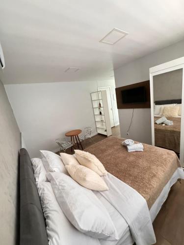 a bedroom with a large bed with pillows on it at 24 Melhor custo benefício Aeroporto e Consulado in Porto Alegre