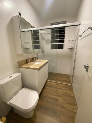 a white bathroom with a toilet and a sink at 24 Melhor custo benefício Aeroporto e Consulado in Porto Alegre