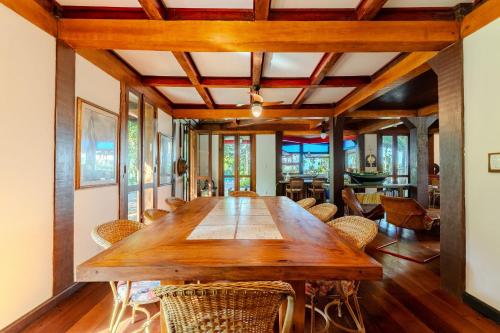 ein Esszimmer mit einem Holztisch und Stühlen in der Unterkunft Paraiso em praia Particular - 2km de Juquey in São Sebastião