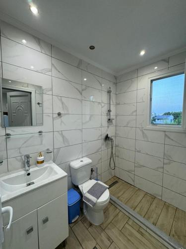 a white bathroom with a toilet and a sink at Suli Apartments in Limenas
