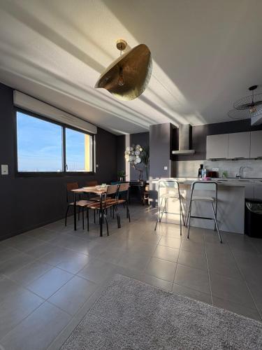 une cuisine et une salle à manger avec une table et des chaises dans l'établissement Appartement unique, coloré en Citadelle, à Dunkerque