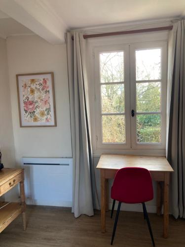 a room with a desk and a window with a red chair at Les chambres d'hôtes Le Val d'Honfleur in Équemauville