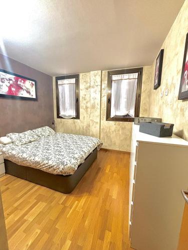 a bedroom with a bed and two windows at APARTAMENTO L AÜT in Pla de l'Ermita