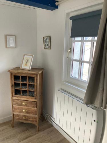 a room with a window and a wooden dresser at Les chambres d'hôtes Le Val d'Honfleur in Équemauville