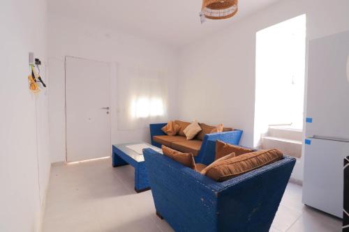 a living room with two blue chairs and a couch at Habitación en casa compartida "Al-Mariya" in Almería