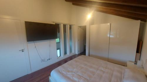 - une chambre avec un lit et une télévision murale dans l'établissement Cosy appartement, à Sarrouilles