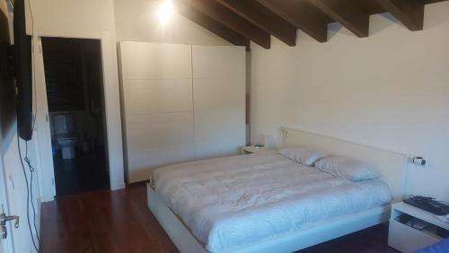 - une chambre blanche avec un lit dans l'établissement Cosy appartement, à Sarrouilles