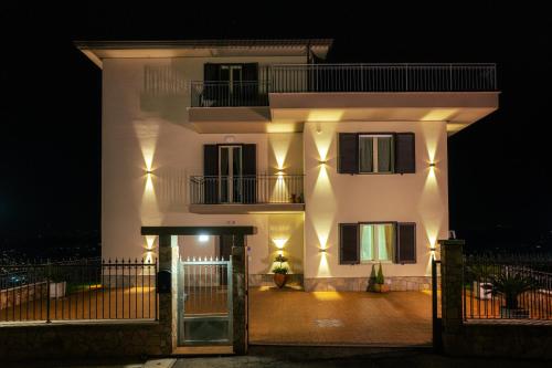 a large white building at night with a fence at Torre dei Venti in Ceccano