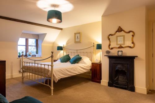 a bedroom with a poster bed and a fireplace at H Oxencombe Farm House in Newton Abbot