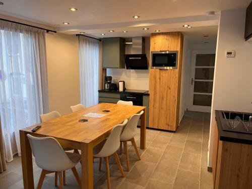 une cuisine et une salle à manger avec une table et des chaises en bois dans l'établissement Appartement cœur de village 1-8 pers, à Barèges
