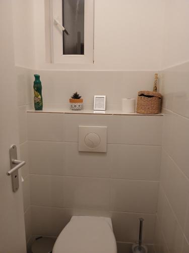 a white bathroom with a toilet and a mirror at Le Refuge du Paradis in Orpierre