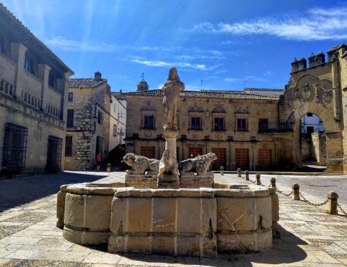 a fountain in front of a building with a statue at Apartamentos Turísticos El AOVE in Baeza