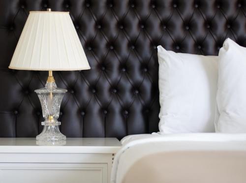 a lamp on a table next to a bed at Casa Bonita Hotel & Luxury Residence in Oaxaca City
