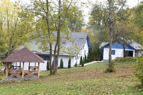 una casa bianca con gazebo in un cortile di Casa Plaiul Cailor: Rustic Mountain Hideaway a Proviţa de Sus