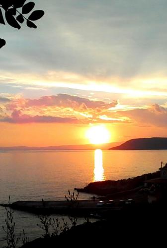 a sunset over a body of water with the sun at Sea And Sun apartments 304 Ιδιωτικό διαμέρισμα in Kardamili