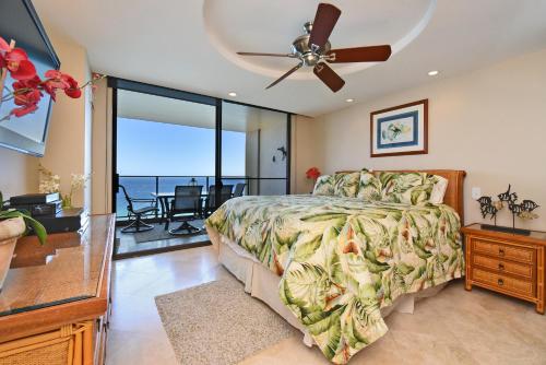 a bedroom with a bed and a ceiling fan at Top Floor Penthouse at The Mahana in Lahaina