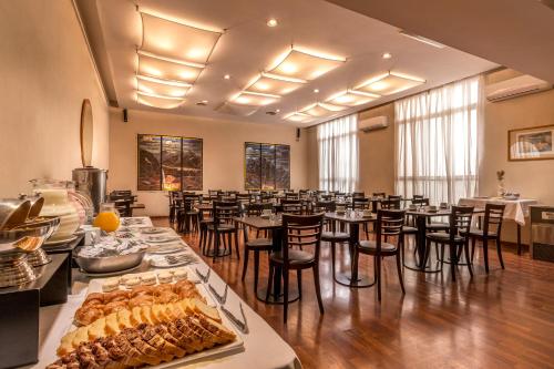 a large room with tables and chairs with food on display at Gran Hotel Argentino in Buenos Aires