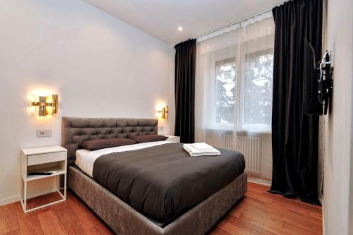 a bedroom with a large bed and a window at Cozy Apartment between Sempione, City Life and MiCo ! in Milan
