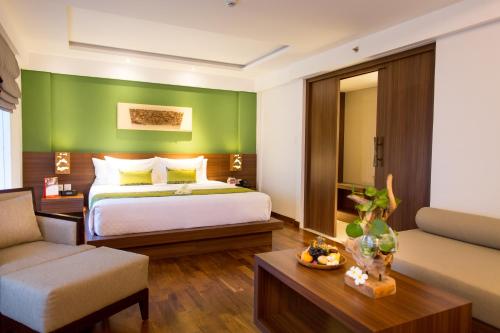 a hotel room with a bed and a couch at d'primahotel Petitenget Seminyak 2 in Seminyak