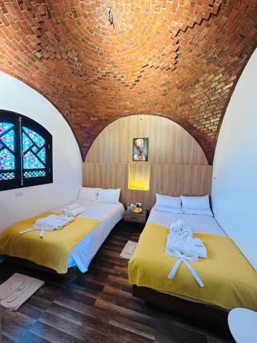 two beds in a room with a brick wall at Villa Farida Palace in Al Aqālitah