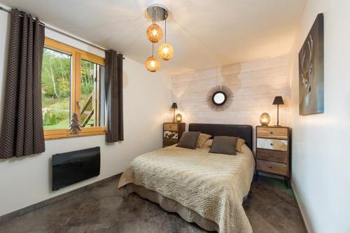 une chambre avec un lit, une télévision et une fenêtre dans l'établissement La clairière aux cerfs, à Ventron