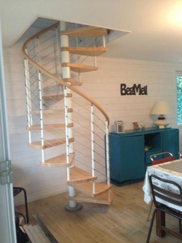 - un escalier en bois en colimaçon dans une chambre avec un bureau dans l'établissement Maison proche mer à Fouesnant Begmeil, à Fouesnant