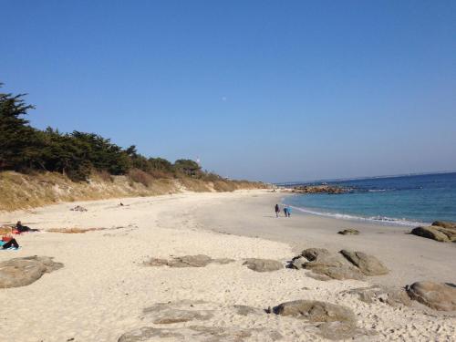 une plage avec des gens sur le sable et l'eau dans l'établissement Maison proche mer à Fouesnant Begmeil, à Fouesnant