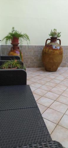 two large vases sitting on a tiled floor at La Rosa del Salento in San Cesario di Lecce