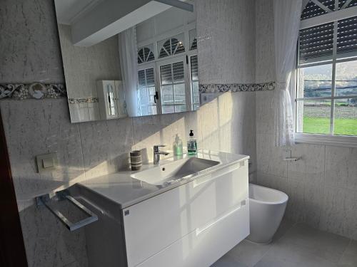 a white bathroom with a sink and a toilet at Casa Victoria - Laxe in Laxe