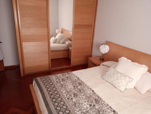 een slaapkamer met een bed en een spiegel bij Espiguiñas in Muros