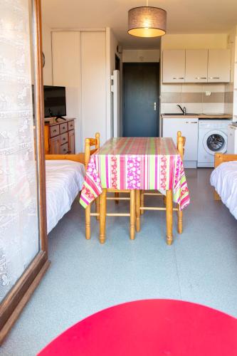 une salle à manger avec une table et un tapis rouge dans l'établissement Appartement avec Balcon proche des thermes, à Barbotan-les-Thermes