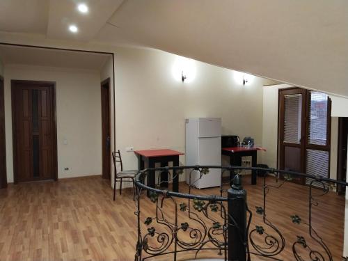 an empty room with two tables and a refrigerator at Villa Vanila in Kutaisi
