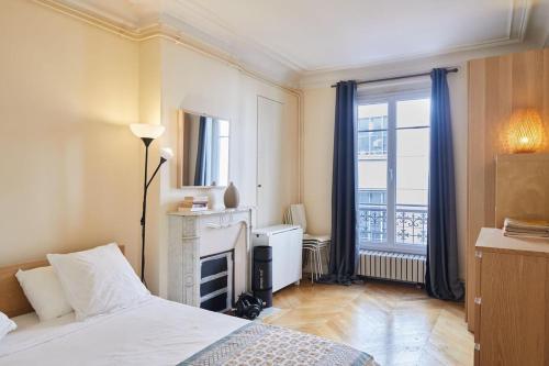 - une chambre avec un lit, une cheminée et une fenêtre dans l'établissement Saint-Germain-des-Prés 60m2, à Paris