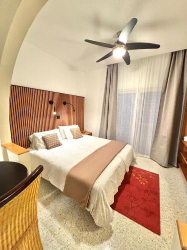 a bedroom with a bed with a ceiling fan at Sands Apartments in St Paul's Bay