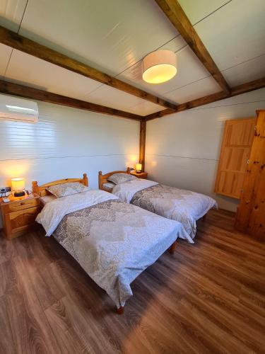 two beds in a room with wooden floors at Vila Zornica in Kondolovo