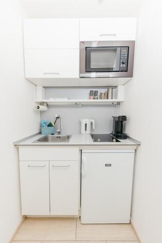 a kitchen with a sink and a microwave at Rosenalm Scheidegg in Scheidegg