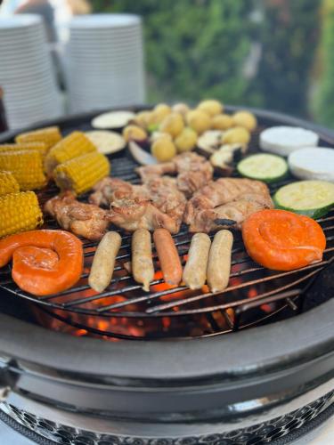 a grill with meat and vegetables on it at Hotel Dolphin - Adult friendly in Senec