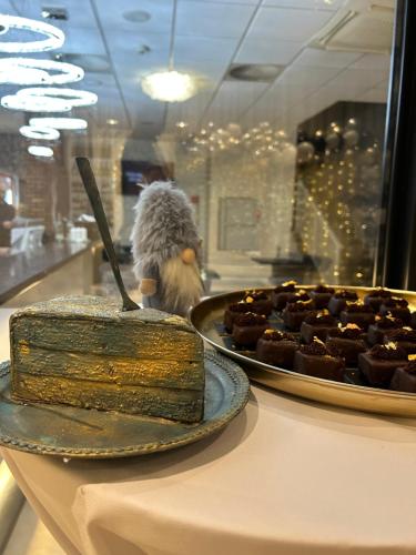 a table with a cake and a plate of food at Hotel Dolphin - Adult friendly in Senec