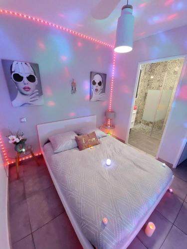 - une chambre avec un lit blanc éclairé dans l'établissement Mini VILLA Coup de Coeur avec Jacuzzi et Sauna Clim Jardin clos et parking sur place, à Ychoux