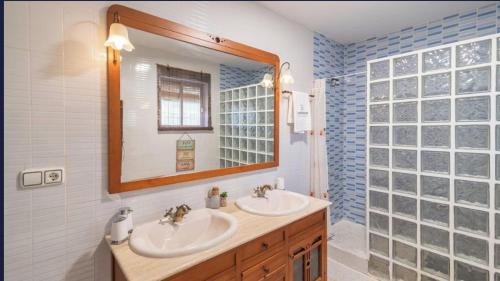 a bathroom with two sinks and a mirror at VILLA CUQUI in Antequera