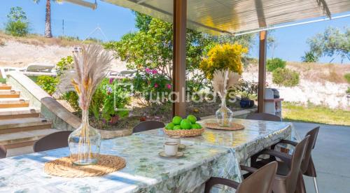 a table with bowls of fruit and vases on it at Villa Dehesa Olive in Lucena
