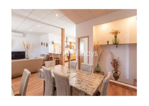a dining room and living room with a table and chairs at Villa Dehesa Olive in Lucena