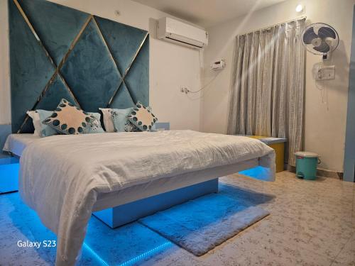a bedroom with a large bed with a blue headboard at Last Minute Deal @ Hotel Sunset in Orchha