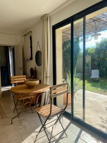 d'une salle à manger avec une table, des chaises et une porte coulissante en verre. dans l'établissement Les Gites du Clos, à La Cadière-dʼAzur